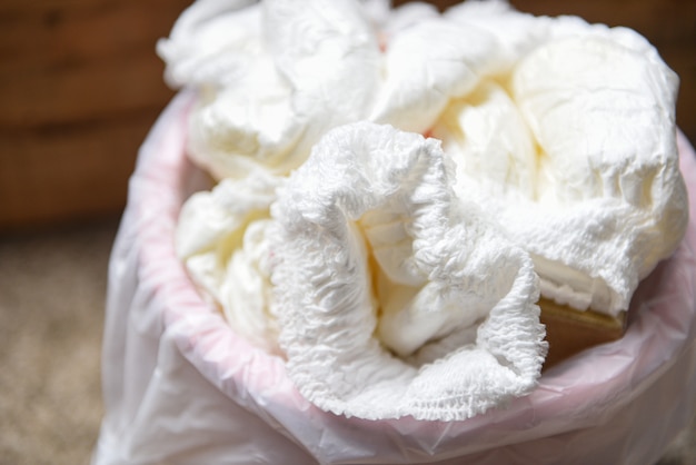 Desperdicios de pañales, pañales sucios en un cubo de basura Desecho de pañales para bebés usados