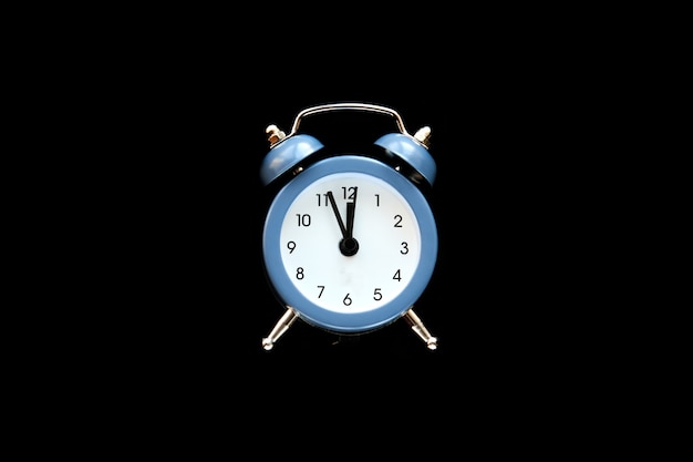 El despertador azul de la vendimia muestra las 12 en punto aisladas sobre fondo negro. Despierta y date prisa. Venta caliente, precio final, última oportunidad. Cuenta regresiva para la medianoche del año nuevo. Copie el espacio para su texto.