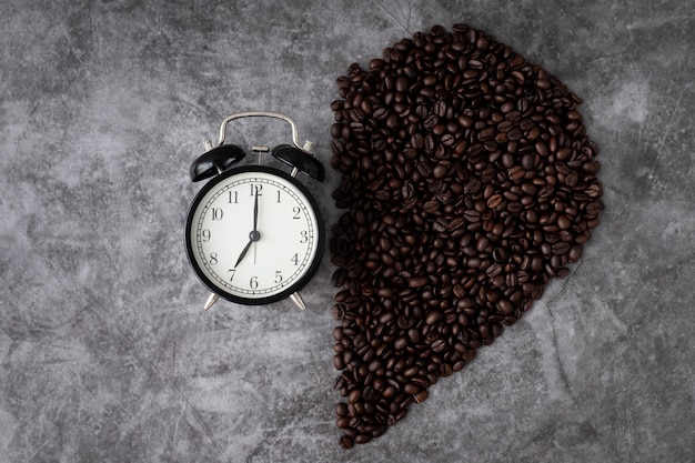 Foto despertador clássico com meio grão de café em formato de coração