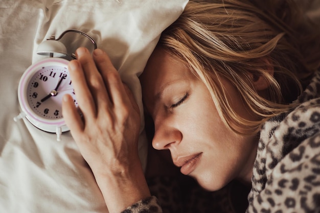 Despertador y mujer dormida El concepto de problemas de sueño insomnio ritmo circadiano