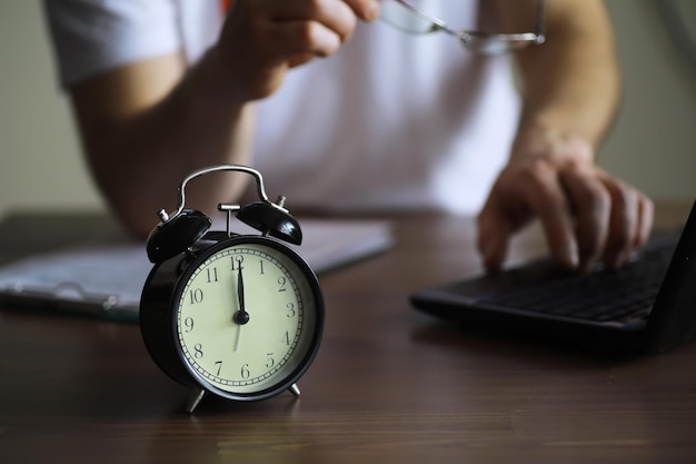 Foto despertador na mesa conceito de tempo estar atrasado para o trabalho e a escola