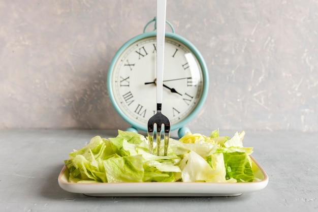 Despertador y plato con lechuga iceberg verde