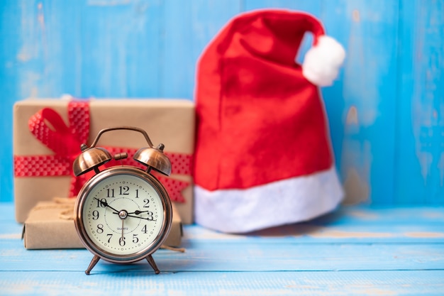 Despertador retrô com caixa de presente de natal feliz ou presente e chapéu de papai noel