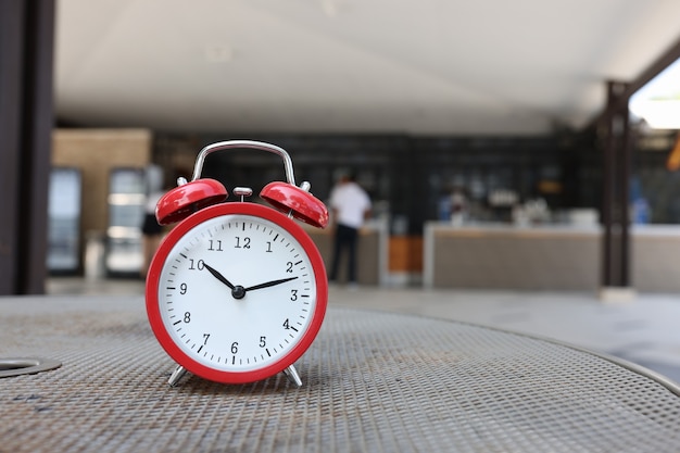 Despertador rojo que muestra la hora de las diez de la mañana en el fondo del mostrador de recepción inicio del