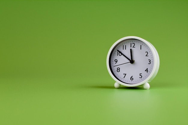 Despertador sobre fondo verde tiempo concepto reloj foto