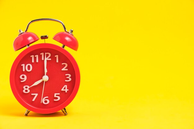 Despertador vermelho fundo amarelo mostrando oito da manhã