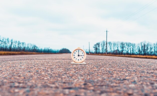 Foto despertador vintage na estrada. hora de viajar conceito