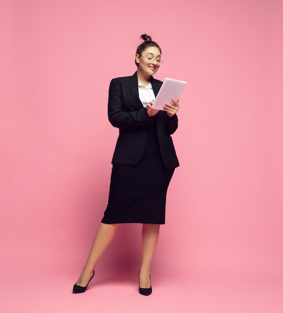 Desplazamiento de la tableta. Mujer joven en traje de oficina. Personaje femenino bodypositive, feminismo, amarse a sí misma, concepto de belleza. Mujer de negocios de talla grande, maestra elegante, hermosa chica. Inclusión, diversidad.