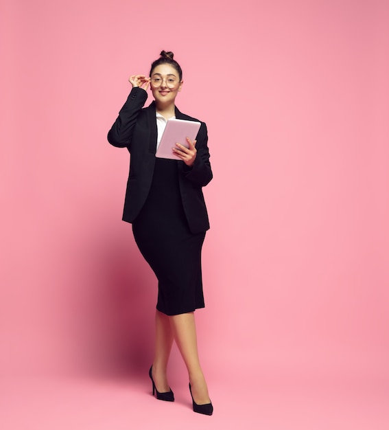 Desplazamiento de la tableta. Mujer joven en traje de oficina. Personaje femenino bodypositive, feminismo, amarse a sí misma, concepto de belleza. Mujer de negocios de talla grande, maestra elegante, hermosa chica. Inclusión, diversidad.