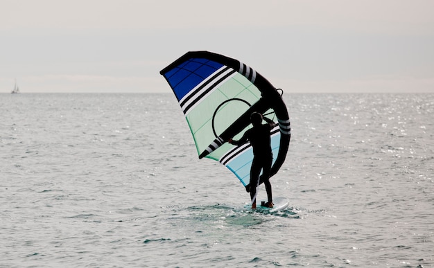 desportista com asa navegando no mar