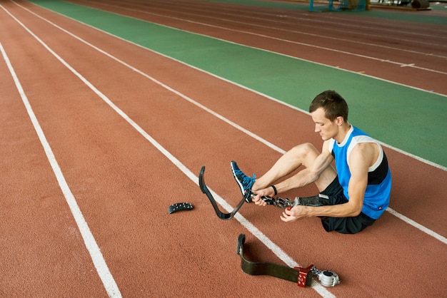 Desportista deficiente que fixa o membro artificial