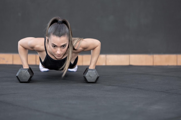 Desportista fazendo flexões em halteres