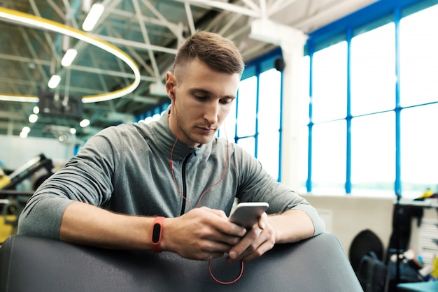 Desportista moderno usando smartphone no ginásio