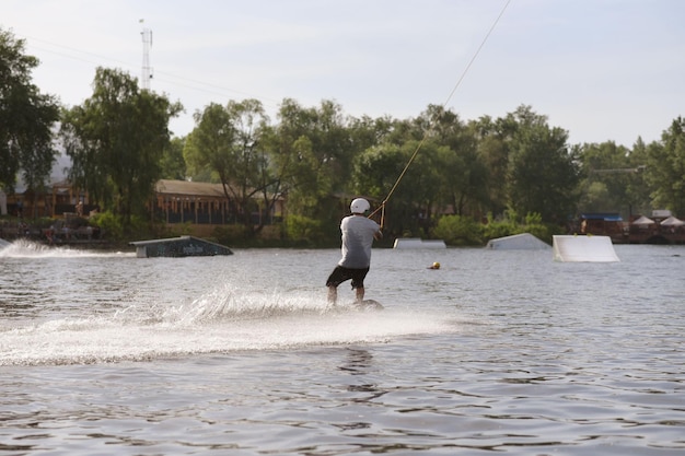 Desportista radical montando a bordo na água e segurando os golpes