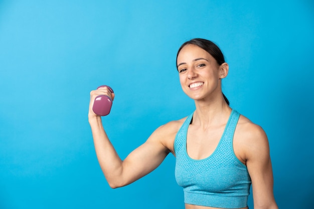 Desportista sorridente, olhando para a câmera e pesos crescentes