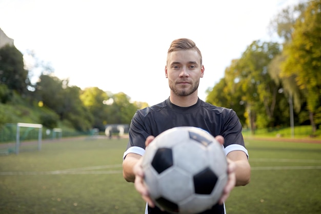 desporto, formação no futebol e pessoas - jogador de futebol com a bola no campo