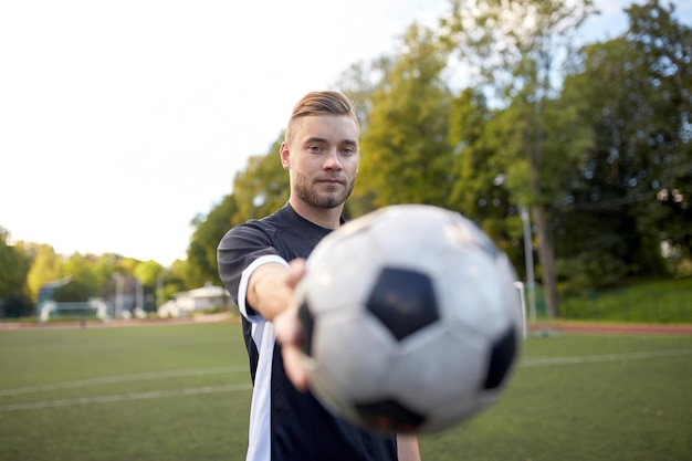 desporto, formação no futebol e pessoas - jogador de futebol com a bola no campo