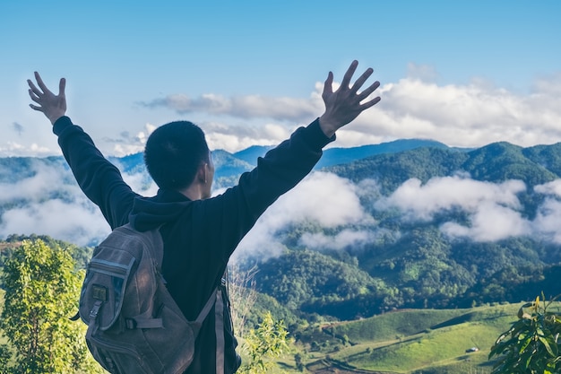 Despreocupado, feliz, homem, desfrutando, natureza, capim, prado, topo, montanha, penhasco, amanhecer