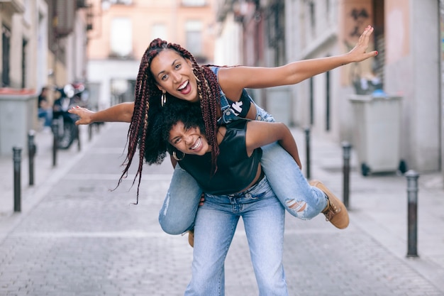 Despreocupado mulheres afro-americanas pulando um no outro