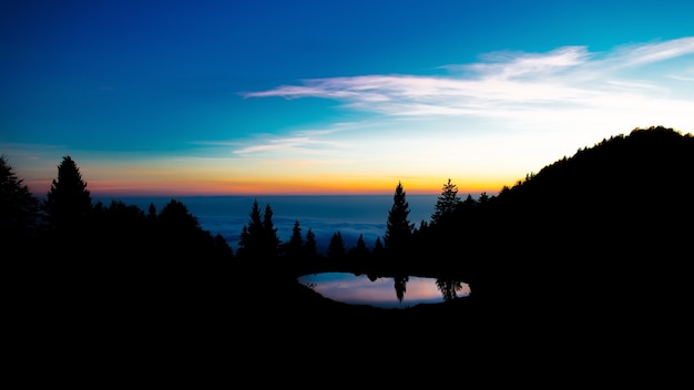 Después del atardecer los colores en un paisaje alpino con un pequeño lago