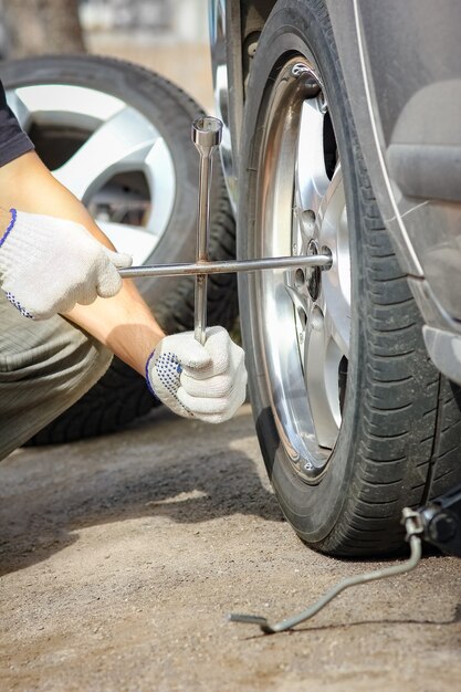 Después de una avería, una persona cambia una rueda de un automóvil a otra rueda con una llave