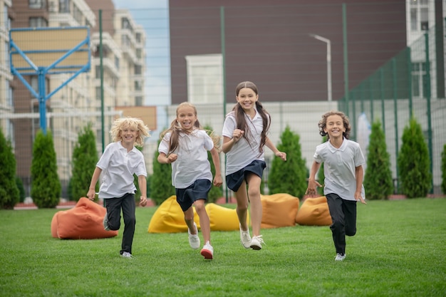 Después del colegio. Grupo de niños corriendo y mirando emocionados.