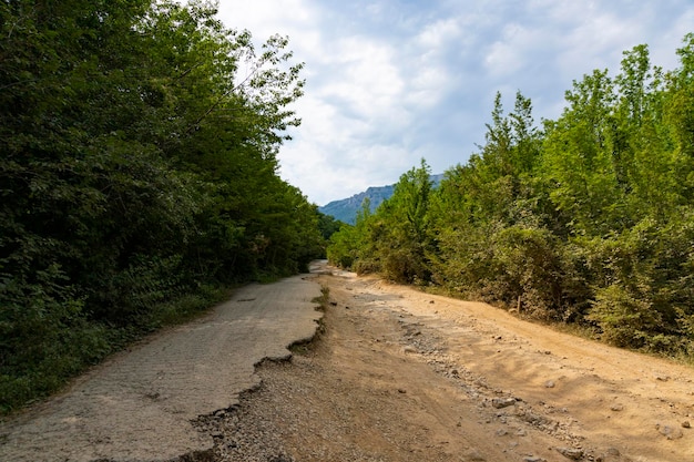 Después de un terremoto y una fuerte tormenta, los restos de una carretera asfaltada en las montañas. Carretera cerrada. Carretera asfaltada destruida. Asfalto roto, crack y derrumbes. foto de alta calidad