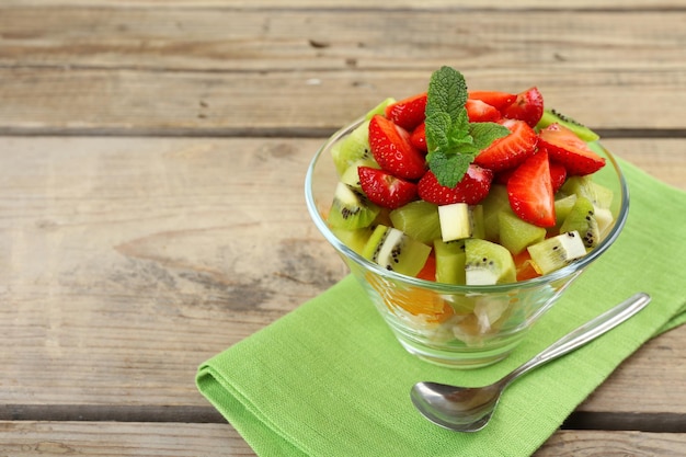 Dessert aus frischen Früchten in Glasuntertasse auf Holztisch in der Nähe