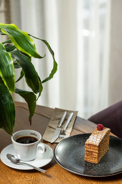 Dessert dekoriert mit Himbeeren, serviert mit Kaffee. Foto des Desserts im Innenraum