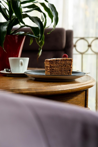 Dessert dekoriert mit Himbeeren, serviert mit Kaffee. Foto des Desserts im Innenraum