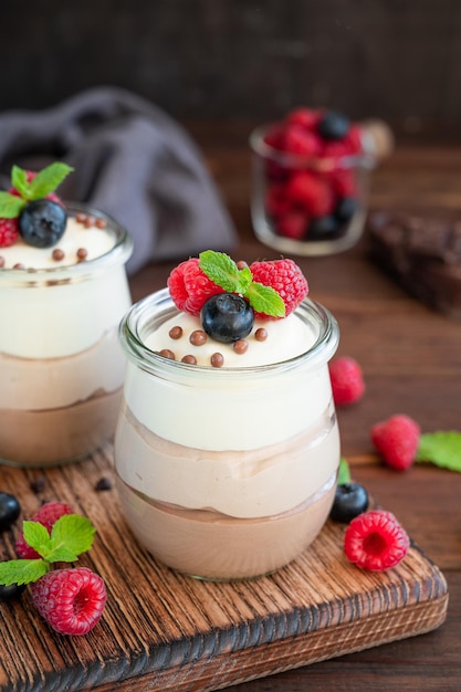 Dessert drei Schokolade in einem Glaskrug mit Beeren Dessert mit drei Schichten unterschiedlichen Geschmacks