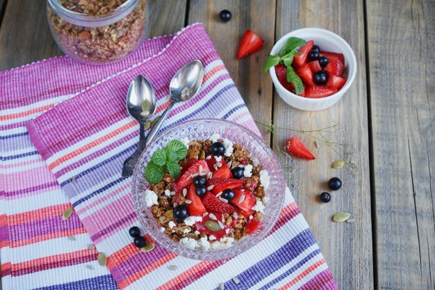 Dessert mit frischen Beeren, Quark, Müsli und Beerenmarmelade.