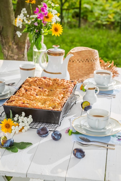 Dessert mit Pflaumenkuchen und Kaffee im Sommergarten
