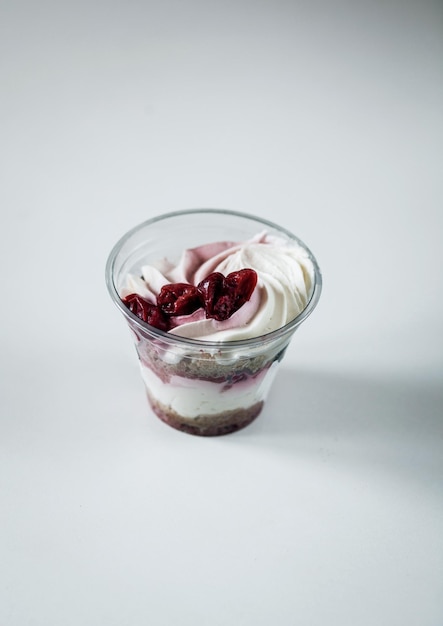 Dessert mit Schlagsahne in einem mit getrockneten Kirschen dekorierten Glas