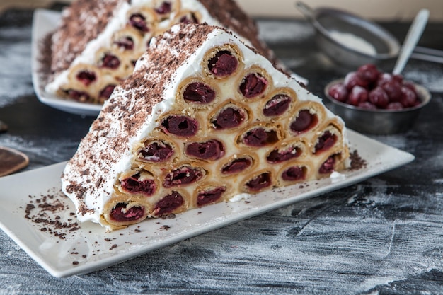 Dessert oder Kuchen bestehend aus Pfannkuchen mit Kirschmilchcreme und Schokolade.