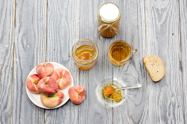 Dessert Pfirsichmarmelade und Tee und Brot closeup auf einem Holztisch