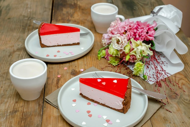 Dessert roter Gelee-Käsekuchen süßes Dessert mit Blumen Tasse Kaffee auf Holztisch Hintergrund Geschenk an die Frau am 8. März Urlaub Valentinstag Frühstück Essen Internationaler Frauentag