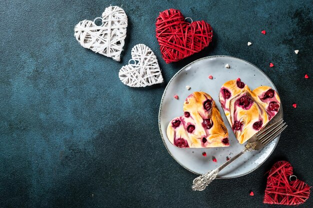 Dessert zum Frauentag. Herzförmiger Käsekuchen-Brownie mit Kirsche. Nachtisch zum Muttertag. Vatertagsdessert. Kuchen zum frauentag. Herz-Käsekuchen. Herzkuchen.