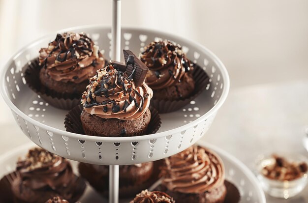 Foto dessertstand mit leckeren schokoladen-cupcakes auf verschwommenem hintergrund