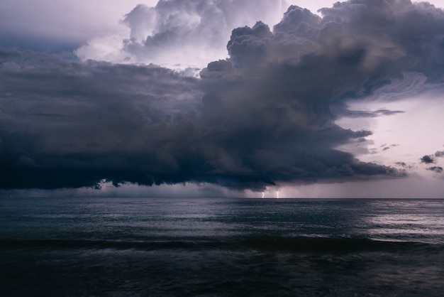 Destello de un rayo en el cielo nocturno sobre el mar, tormenta