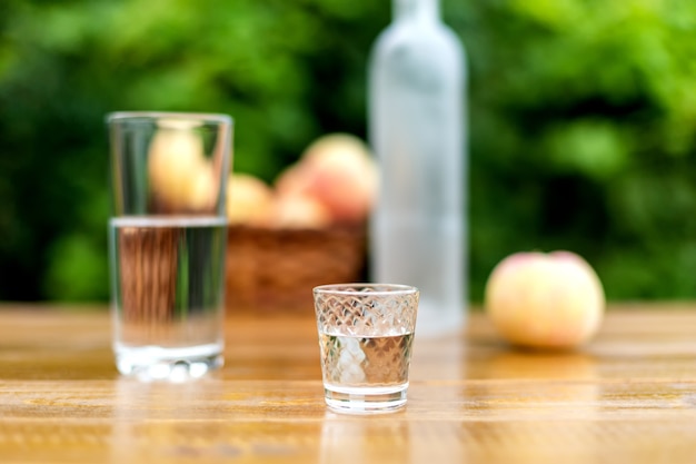 Destilado de brandy de manzana con manzanas en la mesa de jardín