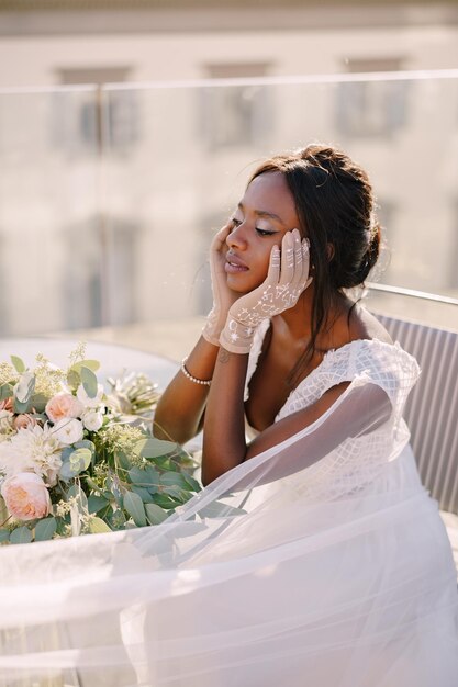 Destination Fineart Hochzeit in Florenz Italien afroamerikanische Braut sitzt am Tisch berührt sie