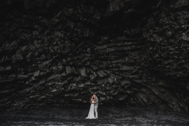 Destino Islândia casamento. Um casal de noivos caminha pela praia negra de Vic.