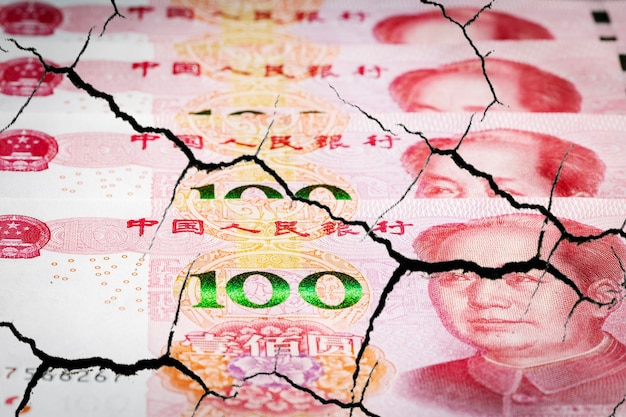 Destruição de notas de yuan da economia chinesa com rachaduras.