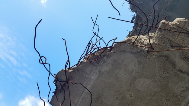 Destruição de uma estrutura de concreto com reforço em um fundo de céu azul. antigo piso de concreto de um prédio abandonado.
