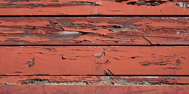 Desvanecimiento pintura roja antiguo edificio de madera exterior piso de madera textura del fondo