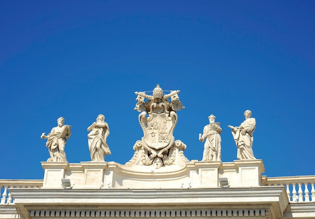 Detail aus der barocken Peterskolonnade mit schönen Statuen von Heiligen und dem Wappen von Papst Alexander VII. Vatikanstadt Rom Italien