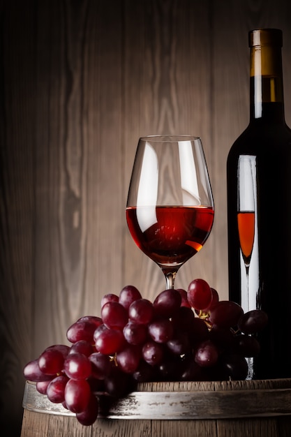 Detail der Flasche und des Glases Rotwein mit Trauben