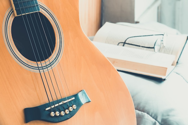 Detail der Gitarre mit Buch und Brillen