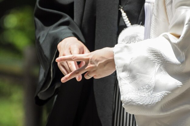 Detail der Hände eines Paares, das in einem japanischen Shinto-Tempel heiratet